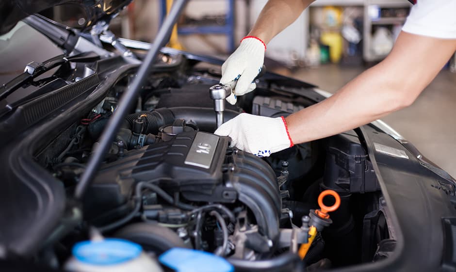 photo of mechanic fixing car engine